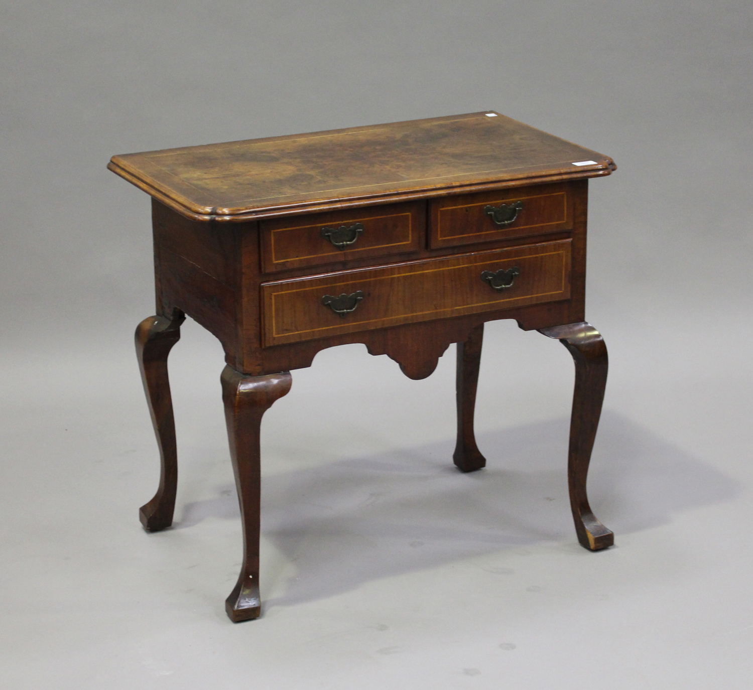 A George II walnut lowboy with boxwood stringing, the moulded edge above two short and one long
