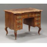 A 19th century Continental Rococo Revival walnut kneehole desk with overall crossbanded borders, the