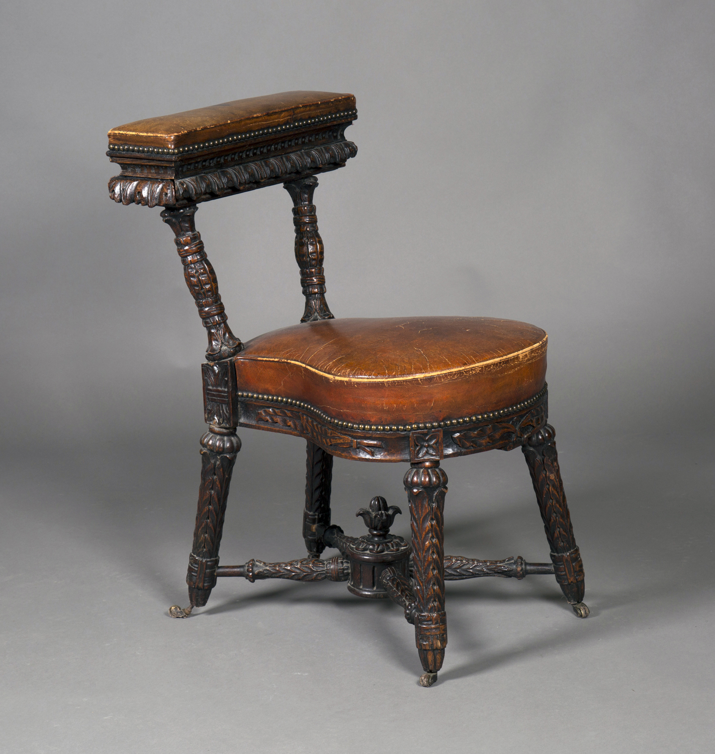 A mid-19th century oak framed cockfighting chair, profusely carved with overall foliage and