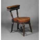 A mid-19th century oak framed cockfighting chair, profusely carved with overall foliage and