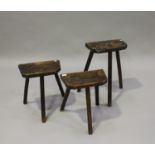 Two 19th century primitive elm ironworkers' stools, each thick shaped rectangular seat raised on