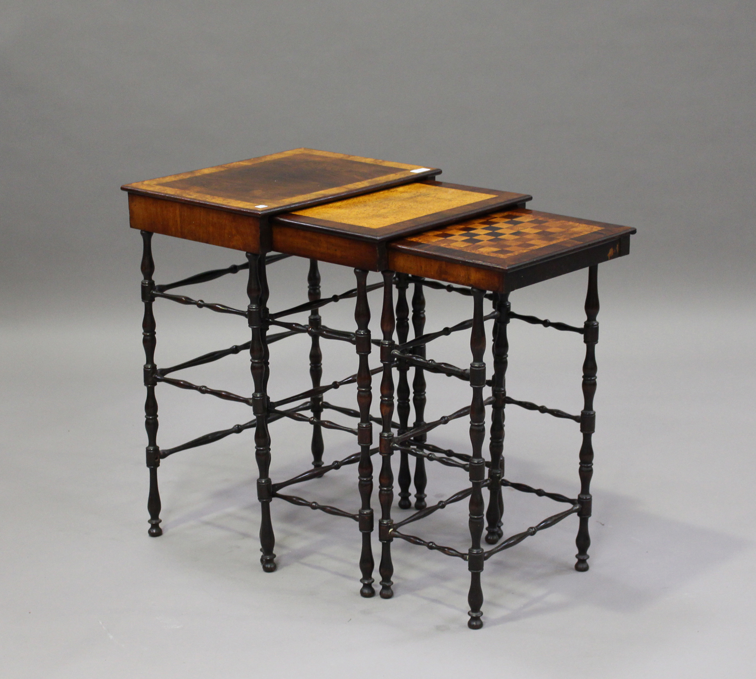 A mid-Victorian rosewood nest of three occasional tables, the largest table crossbanded in burr