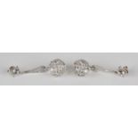 A pair of white gold and diamond pendant earrings, each of loop bar and wirework spherical form,