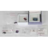 A group of unmounted gemstones, including a rectangular cut cornered step cut blue tourmaline, a