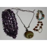 A three row necklace of amethyst quartz beads, a reconstituted amber bracelet, a vari-coloured