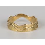 An 18ct gold wedding ring in an abstract design with a textured finish, ring size approx O.Buyer’s