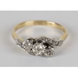 A gold, platinum and diamond three stone ring, mounted with cushion shaped diamonds in a cross-