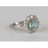 A platinum, blue zircon and diamond cluster ring, claw set with the circular cut blue zircon