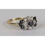 An 18ct gold, sapphire and diamond cluster ring, claw set with the principal circular cut sapphire