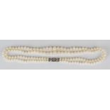 A two row necklace of graduated cultured pearls on a white gold and rose cut diamond set clasp,