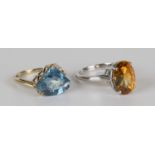 A 9ct gold, blue topaz and diamond ring, claw set with a fan shaped blue topaz and a row of three