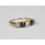 A gold, sapphire and diamond five stone ring, mounted with three cushion shaped diamonds alternating