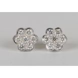 A pair of white gold and diamond cluster earstuds, each mounted with seven circular cut diamonds