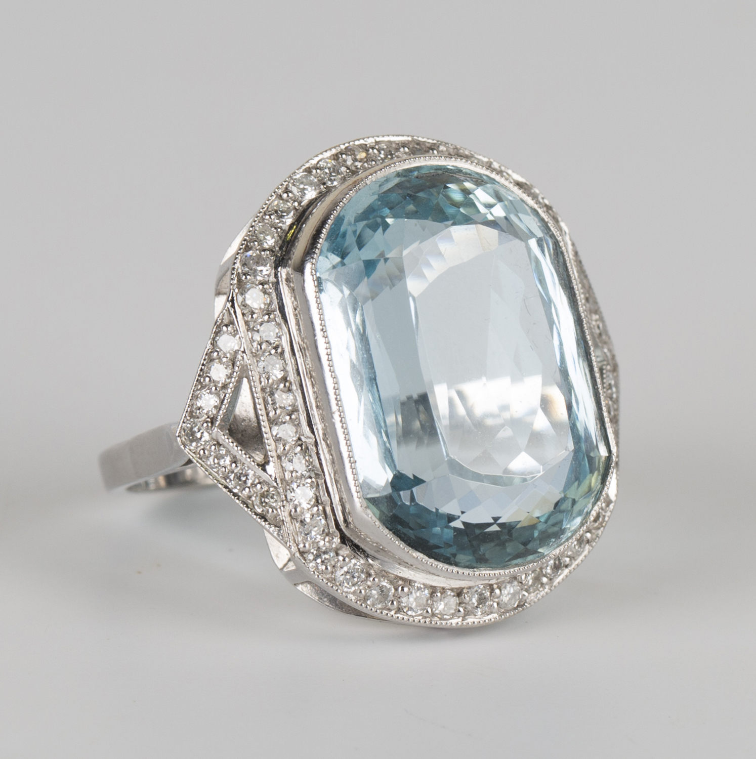 An 18ct white gold, aquamarine and diamond ring, collet set with a large oval cut aquamarine
