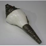 A Tibetan style metal mounted conch shell, the plated mounts with embossed decoration, length 26cm.