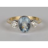 A gold, aquamarine and diamond ring, collet set with an oval cut aquamarine between circular cut