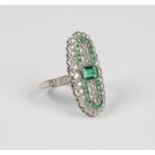 A platinum, emerald and diamond open panel shaped ring, mounted with a cut cornered rectangular