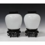 A pair of Chinese Peking white glass jars with hardwood covers and stands, Republic period, each