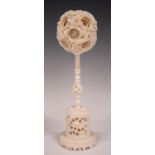 A Chinese Canton export ivory puzzle ball and stand, late Qing dynasty, the outer case carved in