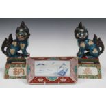 A pair of Japanese Kutani porcelain figures of Buddhistic lions, Meiji period, each turquoise glazed