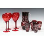 A collection of mostly red tinted glassware, including a Bohemian ruby flash overlay cut jug and