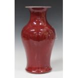 A Chinese sang-de-boeuf glazed porcelain vase, Qing dynasty, of baluster form with flared neck,