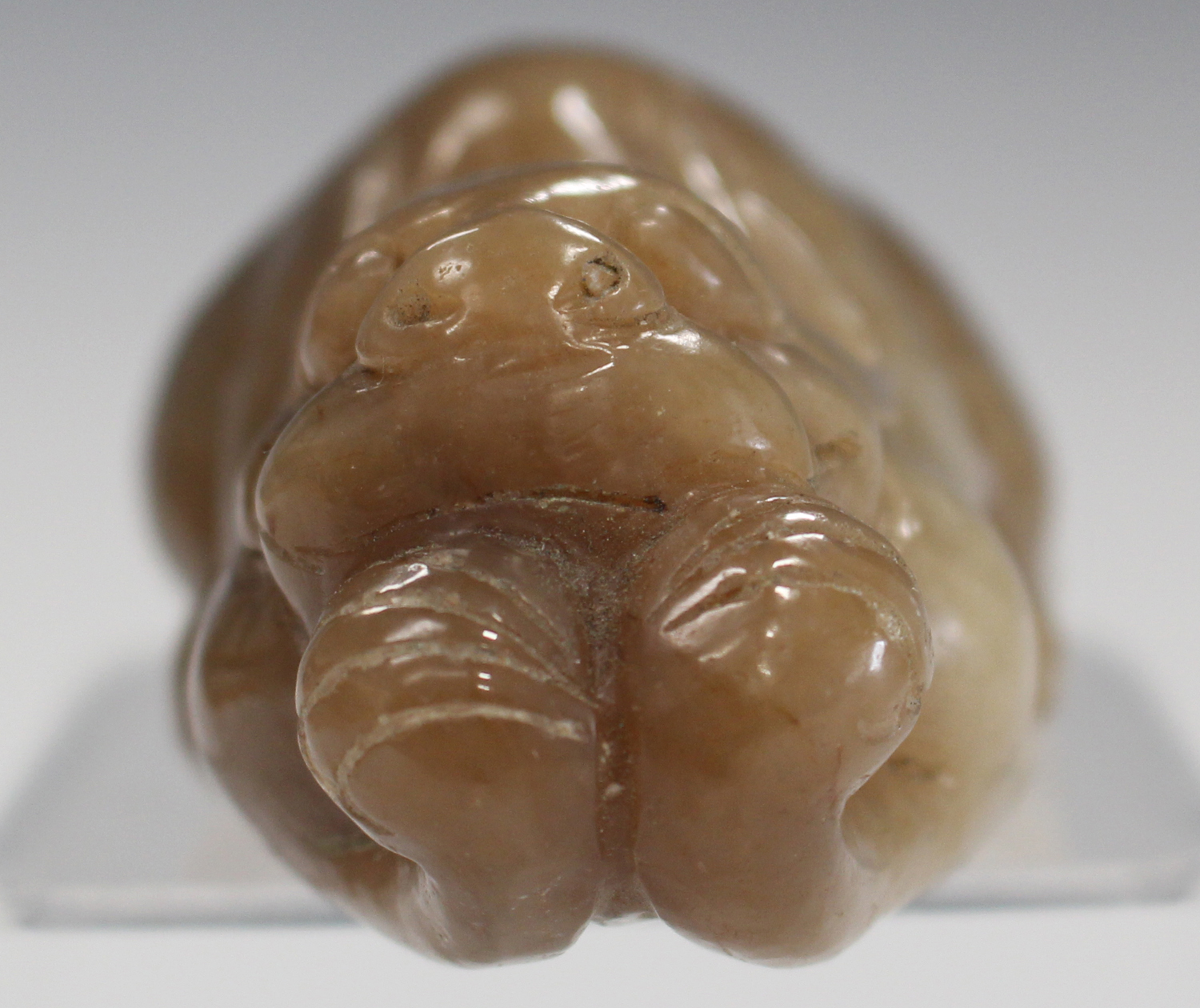 A Chinese brown jade carving, probably late 20th century, modelled as a recumbent crouching feline - Image 6 of 6