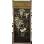 A Japanese silk embroidered hanging scroll, Meiji period, worked in coloured threads with a scene of