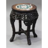 A Chinese hardwood stand, late 19th century, the circular top inset with a famille rose porcelain