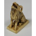 A Japanese carved ivory figural seal, Meiji period, modelled in the form of a seated goat with