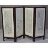 A Chinese hardwood and silk embroidered four-fold screen, late Qing dynasty, each glazed panel