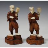 A pair of Japanese boxwood and ivory figures, Meiji/Taisho period, each modelled as a man holding