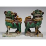A pair of Chinese famille verte enamelled biscuit porcelain jostick holder figures of Buddhistic