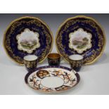 A pair of Coalport porcelain plates, late 19th/early 20th century, painted with titled landscape