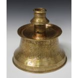 An Islamic brass candlestick, 13th century style but later, the waisted base rising to a dished