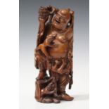 A Chinese carved boxwood figure group of a smiling Buddha, early 20th century, modelled standing and
