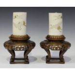 A pair of Japanese ivory tusk vases and wood stands, Meiji period, each tusk section incised and