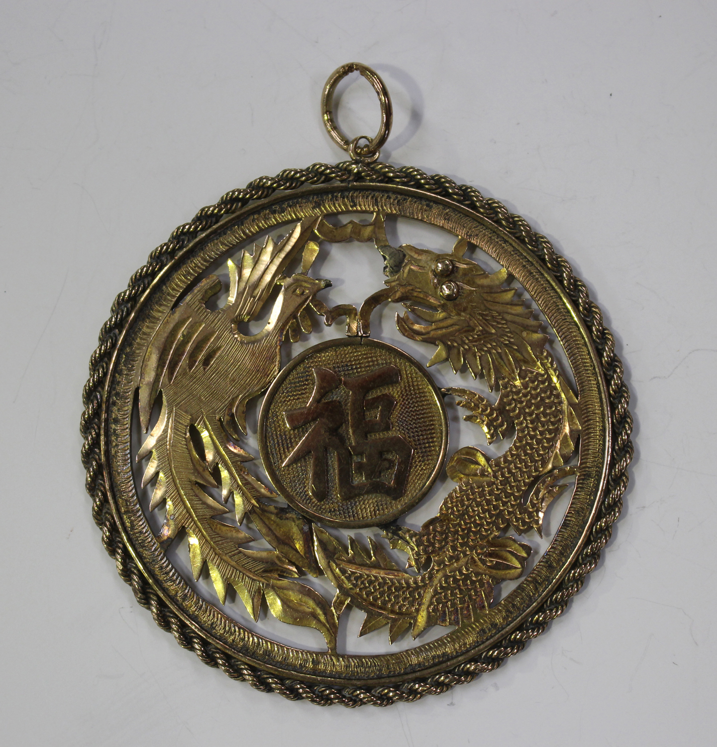A Chinese gold circular pendant, pierced and engraved with confronting dragon and phoenix, centred - Image 2 of 2
