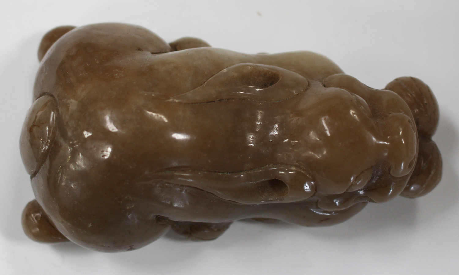 A Chinese brown jade carving, probably late 20th century, modelled as a recumbent crouching feline - Image 3 of 6