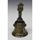 An Indian bronze temple bell, probably 20th century, the turned body with ribbed handle, height