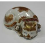 A Japanese Kutani porcelain netsuke, Meiji/Taisho period, modelled as a sleeping cat with iron red