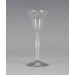 An airtwist stem wine glass, mid-18th century, the pan-topped rounded funnel bowl engraved with a