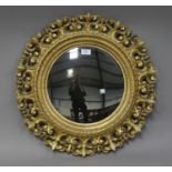 A mid-Victorian giltwood framed circular convex wall mirror with stiff leaf and foliate scroll