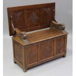 An early 20th century carved oak monk's bench, the triple panelled top above a box seat, on stile