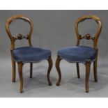 A set of six Victorian walnut spoon back dining chairs, the overstuffed seats on cabriole legs,