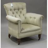 An Edwardian buttoned back scroll armchair, upholstered in green velour, on turned legs, height