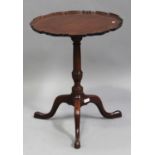A George III mahogany circular tip-top wine table, the carved piecrust top raised on a turned column