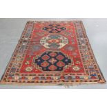 A Kazak rug, West Caucasus, early 20th century, the red field with three large medallions, supported