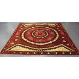 A large Turkish suzani, the woven claret and ivory ground worked with a central medallion, within