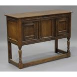 A 20th century oak dresser base, fitted with a pair of panelled doors, raised on turned and block